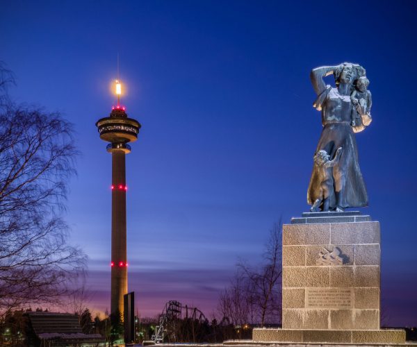 Night view of the Kuru statue in Tampere, expertly illuminated by White Night Lighting. Spotlights close to the statue highlight its details, while a custom-made, cold-toned gobo light creates a striking warm-cold contrast. The precision-engineered gobo is perfectly aligned with a cut-out in the shape of the statue, ensuring there is no spill light and enhancing the statue's dramatic presence against the lit Näsinneula tower in the background.